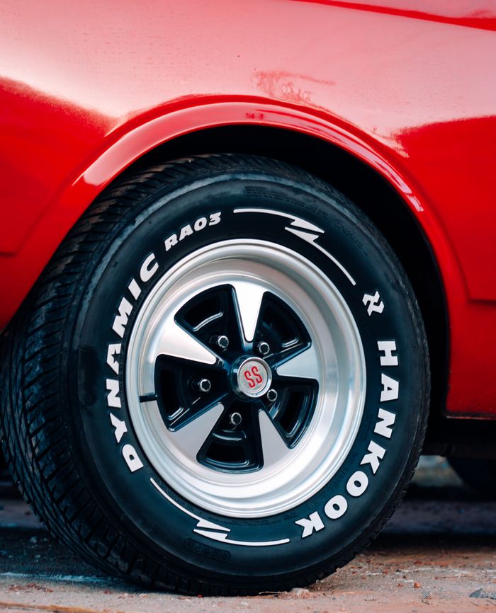services-01 Close-up photo of a red muscle car showcasing a Dynamic RA03 Hankook tire and alloy wheel.