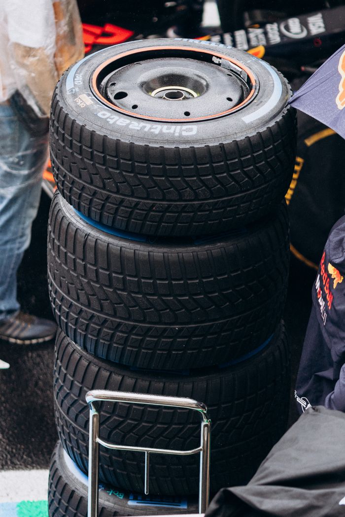 services-01 Close-up of stacked Formula 1 racing tires at a pit stop during a rainy day.