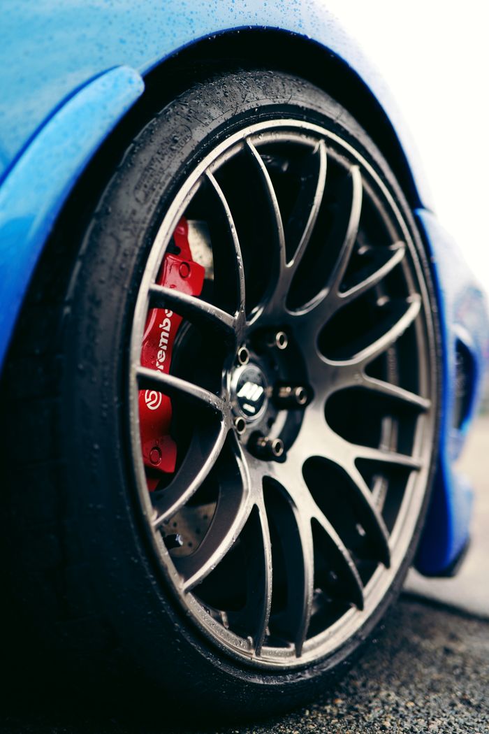 A close-up shot of a car wheel with a detailed view of the Brembo brake system on a blue sports car.