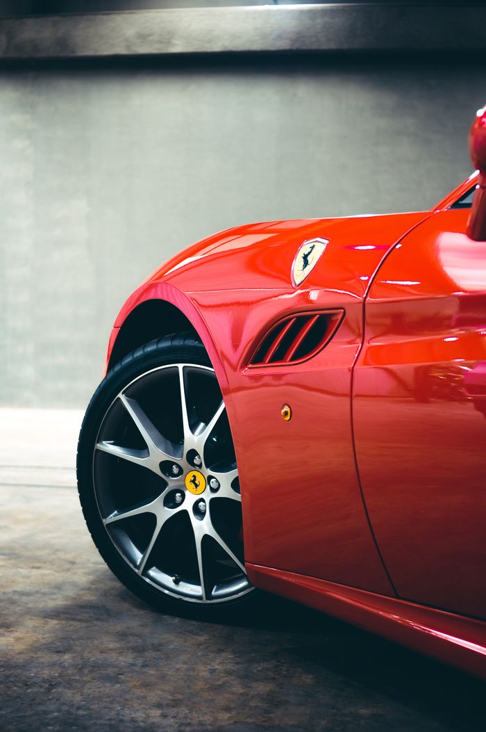 Part of expensive modern sport car with shiny reflective body parked in garage under light